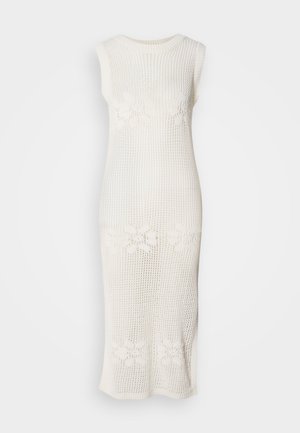 Pikk, valge, ilma varrukateta kleit, mis on valmistatud avatud kudumise materiaalist, millel on lillemustrid vööl. Sirge lõikega siluett.