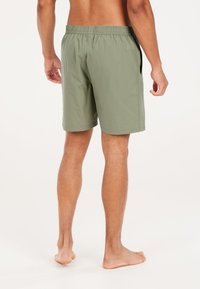 Groene shorts met een elastische tailleband, zijzakken en een gladde, lichte stof. Beseft boven de knie voor een relaxte pasvorm.