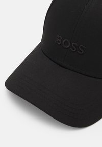 Cappellino da baseball nero realizzato in tessuto strutturato, con logo ricamato "BOSS" nella stessa tonalità sulla parte anteriore.