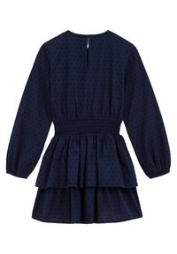 Marinblå klänning med långa ärmar, smockad midja och lagerdesign. Har en texturerad tyg med vertikala mönster och en nyckelhålsöppning i ryggen.