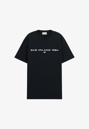 T-shirt in cotone nero con maniche corte, collo rotondo e testo stampato bianco "GAS MILANO 1984" in orizzontale sul petto. Design semplice senza motivi.