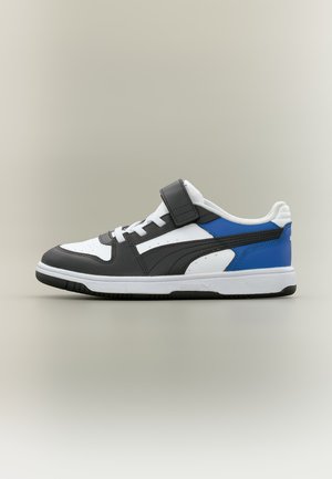Baskets basses blanches, noires et bleues avec lacets et une bride Velcro noire sur un fond neutre.