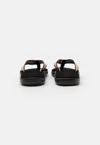Sorte sandaler med strukturerte svarte såler og flerfargede stroppdetaljer. Åpen tå-design med to justerbare stropper for sikker passform.