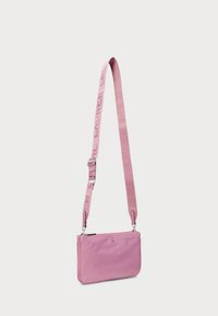 Pink leather crossbody bag with a structured design, featuring a detachable strap with the brand name and silver-tone hardware accents.