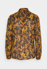 Camisa abotonada de tejido ligero y transparente con un fondo oscuro y vibrantes estampados de hojas en naranja y amarillo. Cuello clásico y mangas largas.