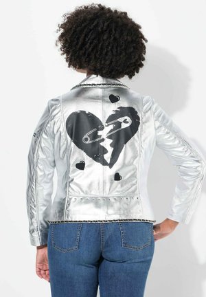 Silver metallic leather jacket featuring a large black heart design with a safety pin, accented by small black hearts and studded embellishments.
