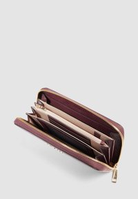 Portafoglio in pelle bordeaux con zip dorata, dotato di più slot per carte e scomparti in un design strutturato.