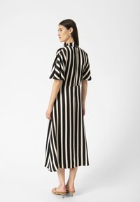 Black and white striped dress with short, flared sleeves and a split hemline. Smooth fabric and a collar detail at the back.