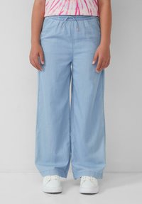 Jasnoniebieskie, luźne spodnie o szerokich nogawkach z elastycznym pasem w talii i akcentami ze sznurkiem; gładka tekstura materiału, prosta konstrukcja.