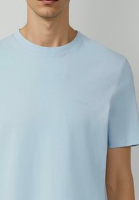 Hellblaues T-Shirt mit kurzen Ärmeln aus weicher Baumwolle. Es verfügt über einen Rundhalsausschnitt und ein dezentes s.Oliver-Logo, das auf der Brust gestickt ist.