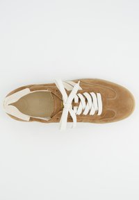 Sneaker en daim marron avec des lacets blancs, un bout arrondi et une semelle beige. Semelle intérieure perforée et bande latérale pour un détail supplémentaire.