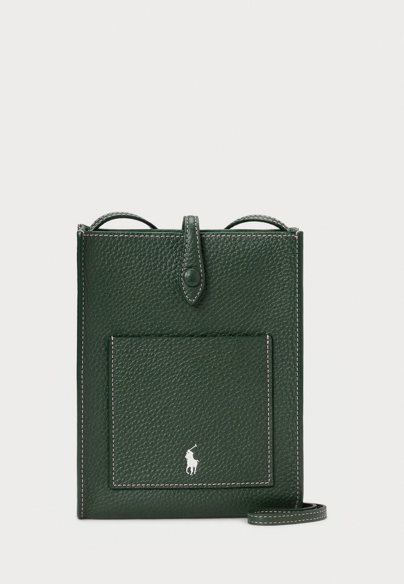 Temnozeleno usnjeno crossbody torbico z teksturirano površino, ki ima sprednji žep in majhen logotip na dnu. Vključena nastavljiva višina traku.