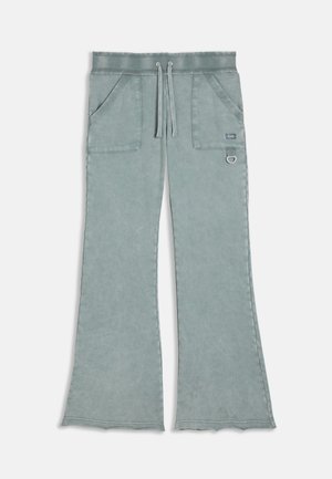 Pantaloni de trening largi, de culoare albastru deschis, cu buzunare frontale, talie cu șnur și detaliu mic din metal pe buzunarul din dreapta.