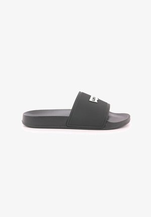 Chanclas negras con una correa texturizada y suela plana, con un detalle del logo en blanco en la parte superior. Fabricadas con material sintético duradero.