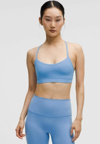 Gaiši zils sporta krūšturis ar plānām siksniņām un gludu, elastīgu audumu. Komplektā ietilpst atbilstošas augstās vidukļa legingu.