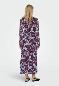 Ilgas, permatomas suknelė su burbuline fono spalva ir mėlynų gėlių raštu. Suknelė turi ilgas rankoves, laisvą kirpimą ir ilgį iki maksi.