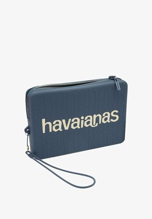 Borsa a pochette in silicone blu con logo "havaianas" in rilievo. Presenta una chiusura con zip e una cintura da polso per una facile maneggevolezza. Tessuto liscio.
