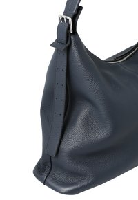 Mørkeblå skuldertaske i læder med tekstureret finish, udstyret med en justerbar rem med sølvfarvet hardware og en lynlåslukning øverst.