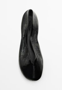 Ballerines noires à surface lisse et brillante, de forme arrondie et au design minimaliste ; présentent un style à enfiler sans matériel visible.