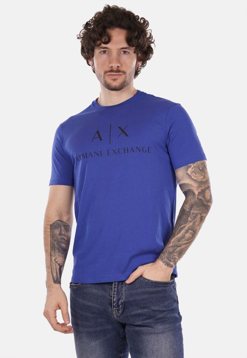 T-shirt in cotone blu con logo grafico nero "A|X ARMANI EXCHANGE" sul davanti, colletto a girocollo e maniche corte. Tessuto testurizzato.