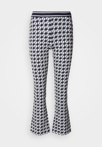 Uitlopende leggings met een marineblauw en wit geometrisch patroon. Ze hebben een aansluitende pasvorm en een elastische tailleband.