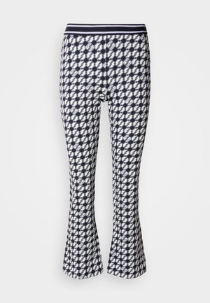 Bredde leggings med et marineblått og hvitt geometrisk mønster. De har en tettsittende silhuett og en elastisk midje.