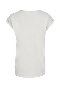 Light beige short-sleeve t-shirt made of soft cotton. Round neckline, relaxed fit, with rolled cuffs and a smooth texture.
