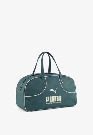 Teal Puma sporttas met twee handvatten, witte biezen, ritssluiting en "PUMA MACHT'S MIT QUALITÄT" gedrukt op de voorkant.