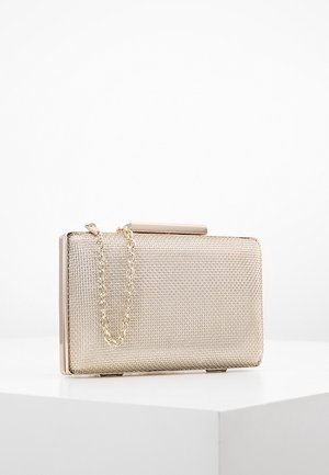 Mała prostokątna kopertówka z złotej siateczki z złotym łańcuszkowym paskiem, leżąca na białej powierzchni na jednolitym tle.