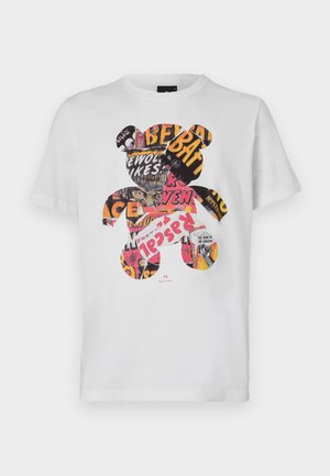 T-shirt en coton blanc avec un graphique d'ours rempli de découpages colorés de magazines et de texte, col rond, manches courtes.