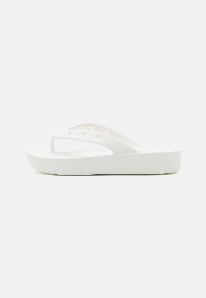 Tongs blanche avec semelle épaisse et dessous texturé, présentée de côté sur fond uni clair. Aucune marque visible.