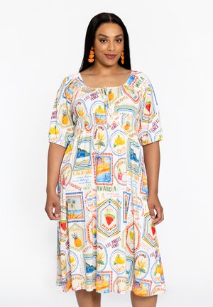 Buntes Kleid mit tailliertem Oberteil und vollem Rock, das ein tropisches Obstmuster auf weißem Stoff zeigt. Kurze Puffärmel, runder Ausschnitt.