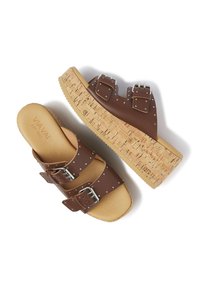 Sandales à talon compensé marron avec semelle en liège, dotées de deux brides avec boucles en métal et accents en studs argentés. Tige et semelle intérieure en cuir lisse.