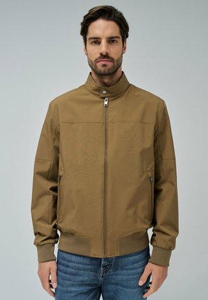 Chaqueta bomber marrón con cierre delantero, cuello alto, bolsillos laterales y puños acanalados. Fabricada en un material textil suave de acabado mate.