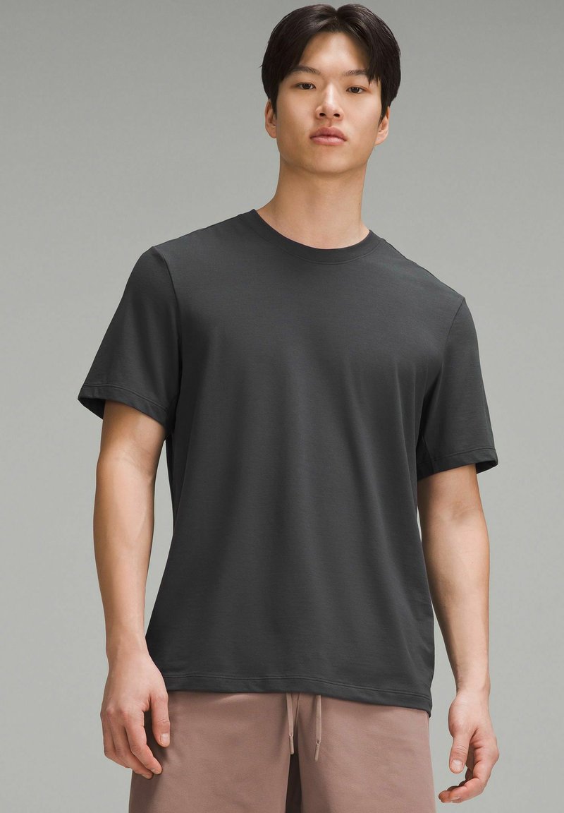Dunkelgraues T-Shirt mit kurzen Ärmeln und Rundhalsausschnitt, aus weichem Stoff gefertigt. Bietet einen entspannten Schnitt und eine glatte Textur.