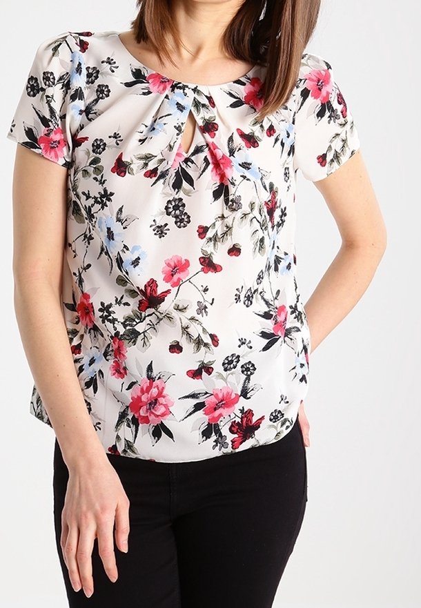 Floral blouse in lightweight, white fabric with pink, red, and blue flowers. Features short sleeves and a keyhole neckline detail.