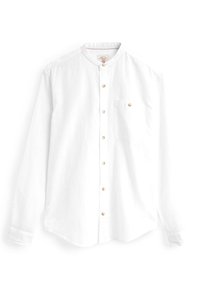 Bílá dlouhá košile s dlouhým rukávem z lnu, s mandarin límcem, přední kapsou a dřevěnými knoflíky podél zapínání. Měkká textura.