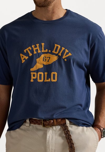 Tricou din bumbac de culoare albastră marină, cu mâneci scurte, având un imprimeu grafic galben: "ATHL. DIV. 67" și "POLO" pe piept.