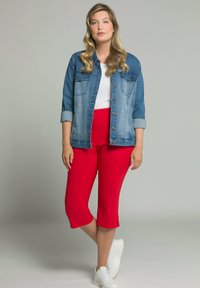 Veste en jean avec un dégradé de bleu, poches avant, boutons ; haut blanc ajusté ; pantalon rouge court ; baskets blanches ; texture douce.