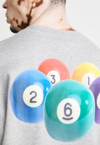 Gray t-shirt featuring a large graphic of colorful billiard balls, displaying numbers 1, 2, 3, and 6 with a glossy texture.
