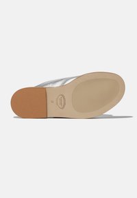 Srebrne ravne cipele s glatkom metalik završnom obradom, okruglim vrhom i smešnim gumiranim đonom. Imaju utisnut logo na unutrašnjosti.