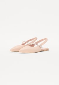 Slingback shoes in pale pink faux leather, pointed toe, feature a decorative strap with clear embellishments and a flat wooden sole.