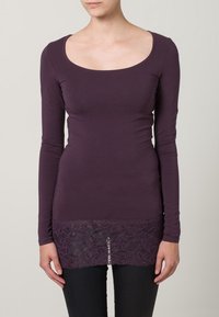 Haut à manches longues en coton violet foncé avec un col en U, orné d'un ourlet en dentelle avec des détails de motif floral en bas.