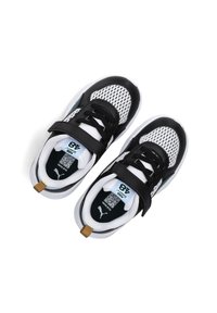 Scarpe sportive in bianco e nero con tomaia in rete, suola in gomma, fascia in velcro e un accento dorato sul tallone, presentando una silhouette da sneaker.