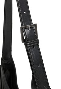 Mustast nahast rihm tekstuurse viimistlusega. Omab tumedas toonis metallist pandlat, mille suurust saab reguleerida mitme auguga.