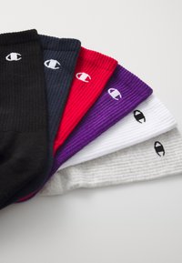 Seis pares de calcetines acanalados en negro, marino, rojo, púrpura, blanco y gris, cada uno con un pequeño logo en colores contrastantes en el costado.