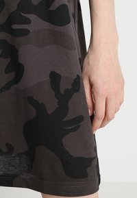 Black and dark gray camo-patterned cotton dress, featuring a smooth texture and short sleeves, with a hemline at mid-thigh.