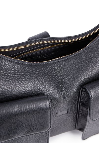 Borsa in pelle nera con finitura texture, dotata di una zip dorata e due tasche esterne. L'interno è scuro e spazioso.