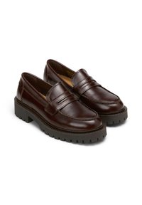 Bruine leren loafers met een dikke platformzool, voorzien van stikseldetails en een band over de bovenkant. Gladde textuur en ronde vorm.