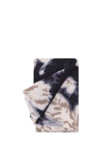 Coperta in pile con motivo tie-dye in tonalità di beige, blu navy e grigio, caratterizzata da una texture morbida e bordi arrotolati.
